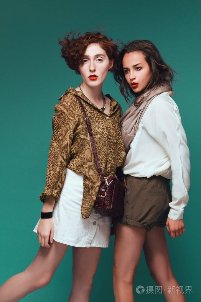 在绿色背景上的两个漂亮的女孩