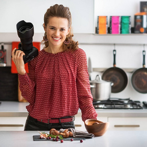 微笑的女性美食摄影师在厨房里的肖像