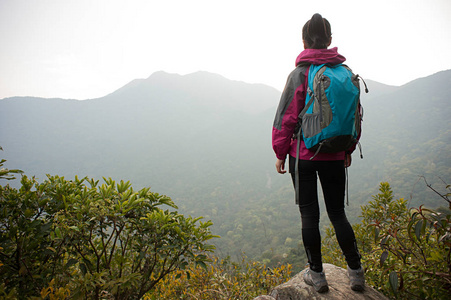 背包里站在山峰上的女人图片