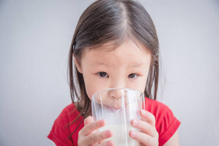 小亚洲女孩喝玻璃牛奶