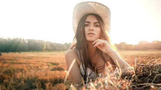 农村女孩在稻草中字段 牛仔帽 漂亮的女人在干草堆上