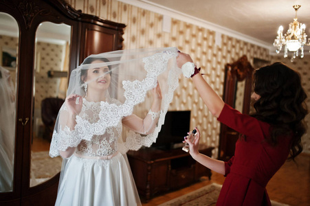 年轻人和华丽的伴娘在她的房间在婚礼上穿的新娘
