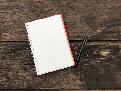 用笔在木桌上，经营理念的空白笔记本