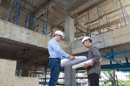 建设概念，工程师和建筑师在建筑地盘工作与蓝图