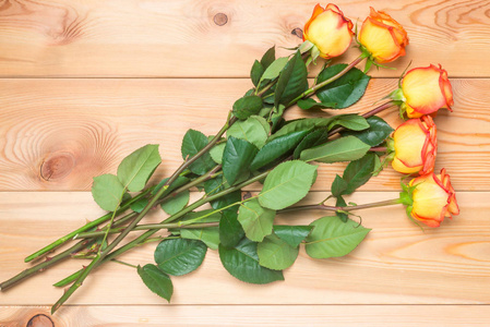 躺在木板上的五个玫瑰的美丽花束