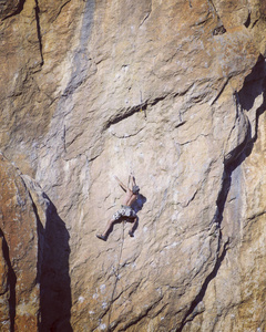 宽阔的山谷的背景与石灰石墙上爬的岩石 Climber.Young 人