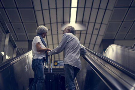 夫妇在机场航站楼乘坐自动扶梯图片