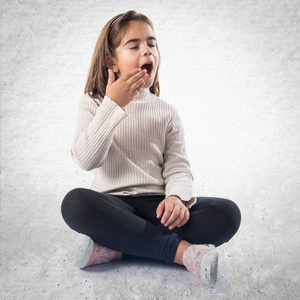 打呵欠的黑发小女孩一个小女孩打呵欠亚洲小女孩看书时伸懒腰无聊,女