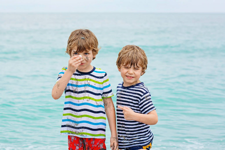 两个小孩子运行在海洋沙滩上的男孩