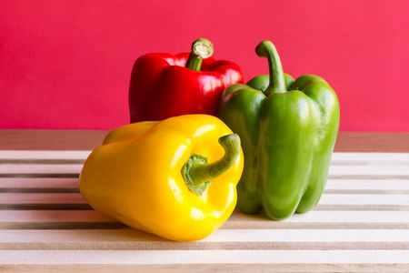 辣椒黄 绿 红辣椒白色与红色背景木板。胡椒是可用于烹饪的蔬菜。关闭
