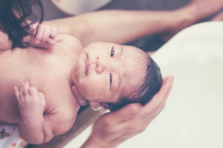 初生女婴与母亲帮忙洗澡