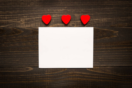情人节的背景。用红色的心，在木桌上的情人节卡片
