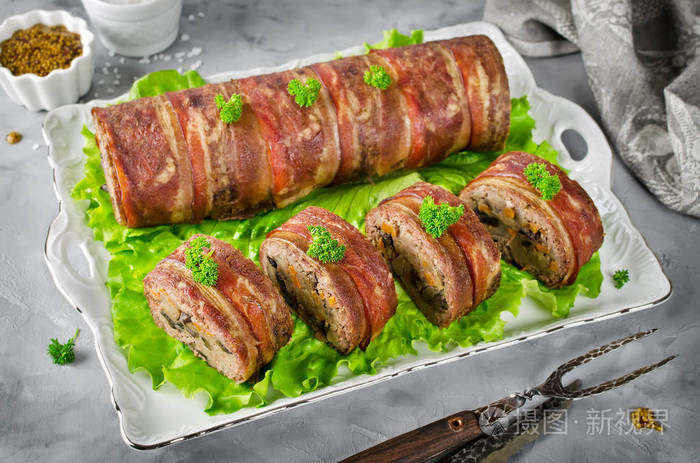 烤箱烤烘肉卷配培根对混凝土的灰色背景