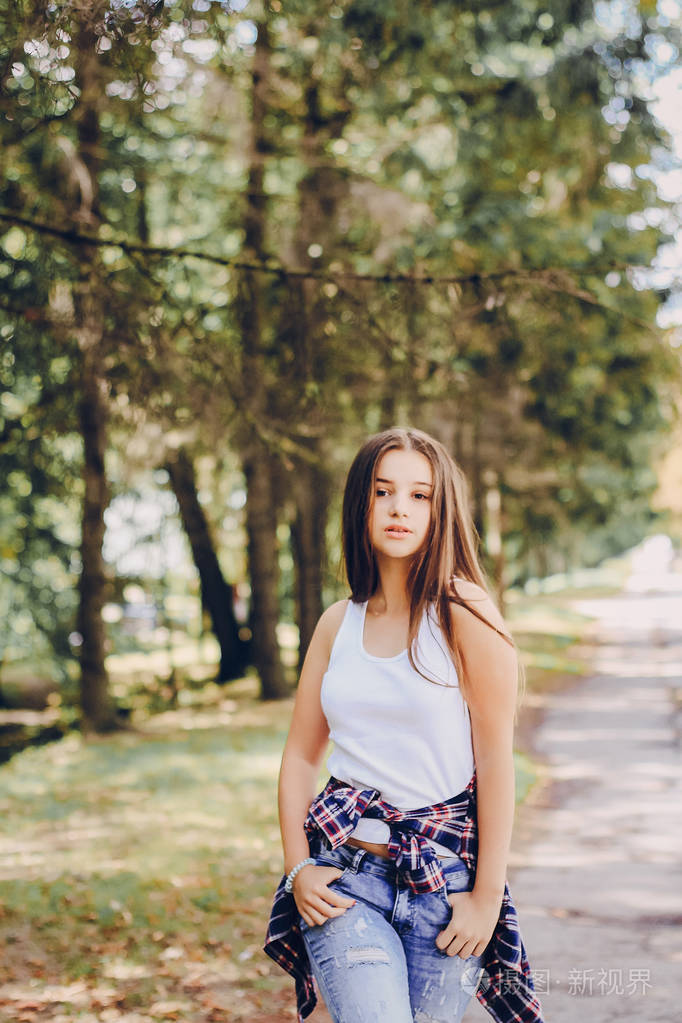 年轻漂亮的女孩步行公园