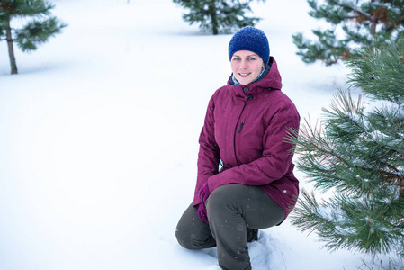 美丽的女人在松树林中雪吹