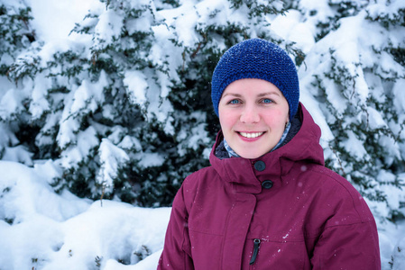 美丽的女人在松树林中雪吹