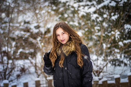 与雪背景微笑留长发的女孩。特写