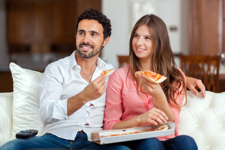 夫妇在沙发上吃披萨