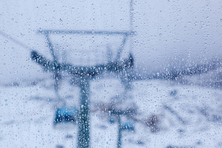 水滴在滑雪场的滑雪缆车在客舱内玻璃上