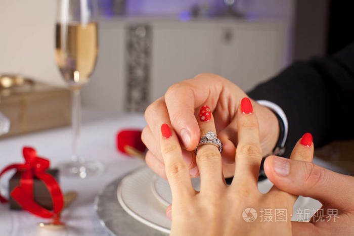 优雅的男人把订婚戒指放到他的女友手