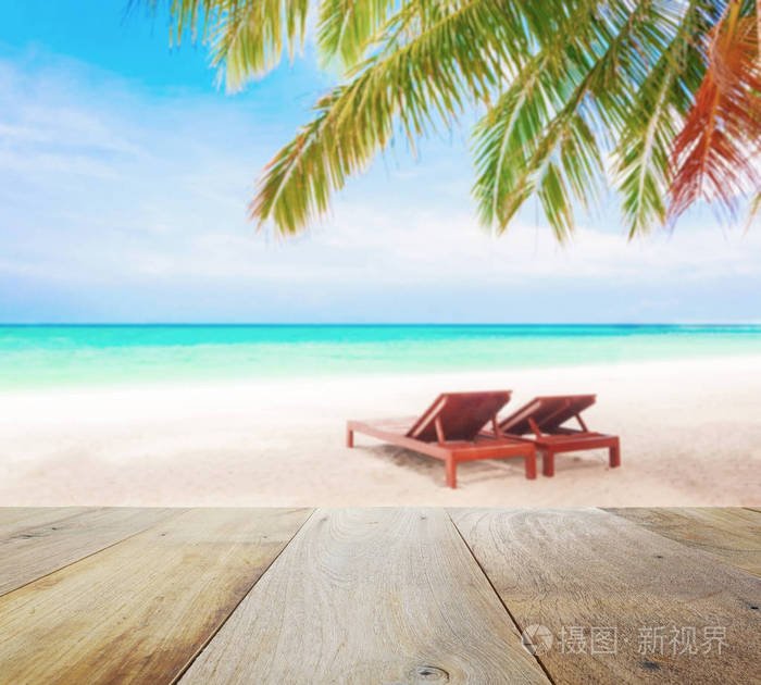 木桌上的模糊与沙滩椅下的椰子树海滩背景