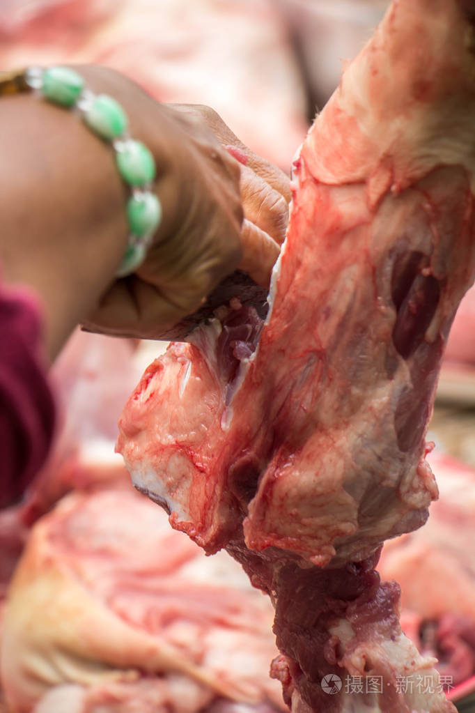 在厨房里烹饪烤猪肉的女人: 切肉