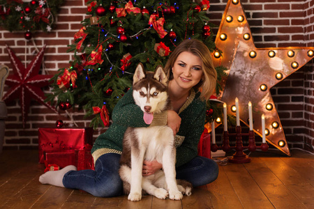 女孩拥抱赫斯基狗靠近圣诞树