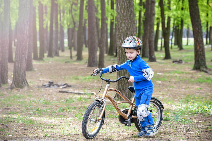 辆自行车在阳光灿烂的夏天的一天,在户外玩的快乐可爱的金发孩子男孩