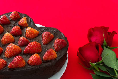心形蛋糕和红色的玫瑰情人节或母亲节红色背景上