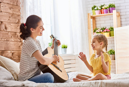 女人弹吉他为儿童女孩