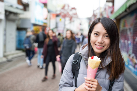 女人享受她在街的黑纱蛋糕