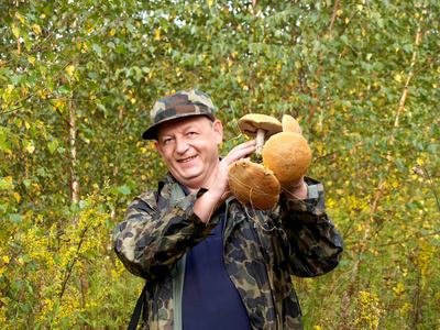 这个开朗的人手里拿着蘑菇专注于蘑菇