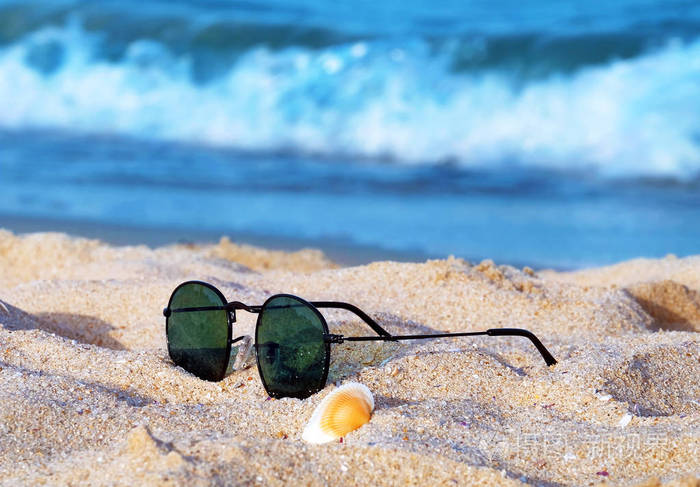 顶视图的太阳镜蔚蓝的大海与沙滩附近的海滩上