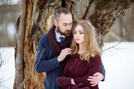 时尚美丽的年轻夫妇新郎和新娘站在冬季景观河道的背景