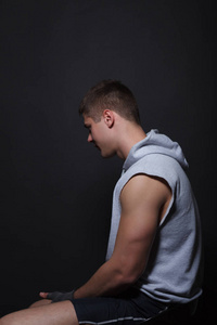 坐在椅子上一个黑色的背景侧身到相机上的肌肉战斗机照片