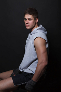 坐在椅子上一个黑色的背景侧身到相机上的肌肉战斗机照片