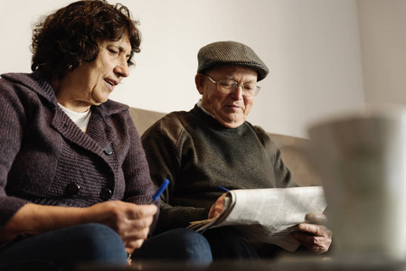 老年夫妇在看报纸。