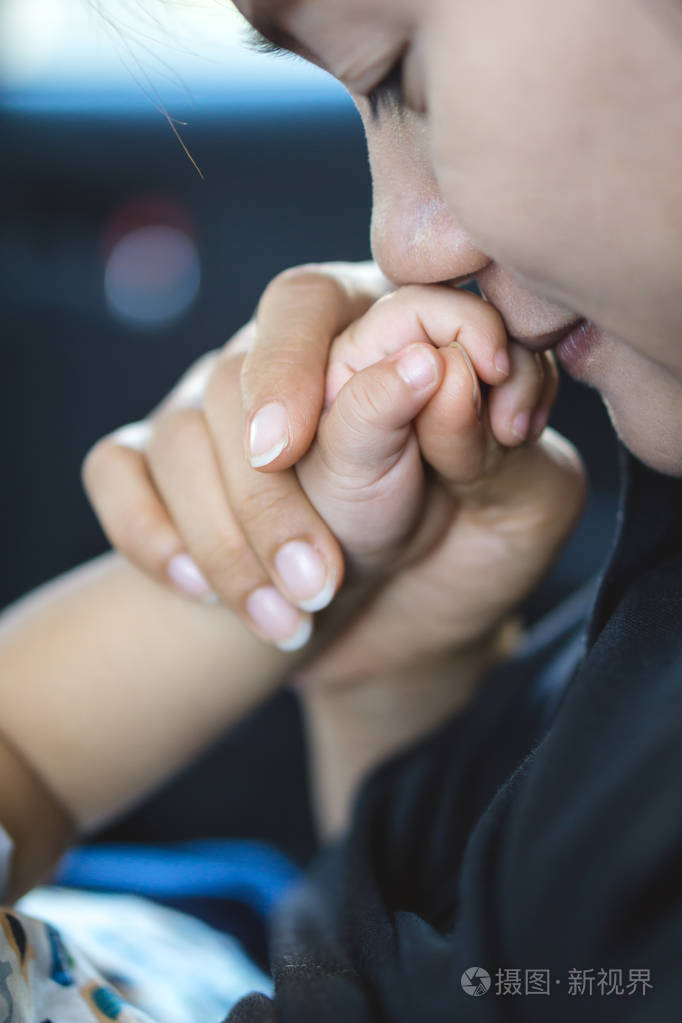 旧的一年亚洲宝宝握着与他的母亲的手