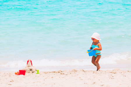 可爱的小女孩在海滩上玩沙子