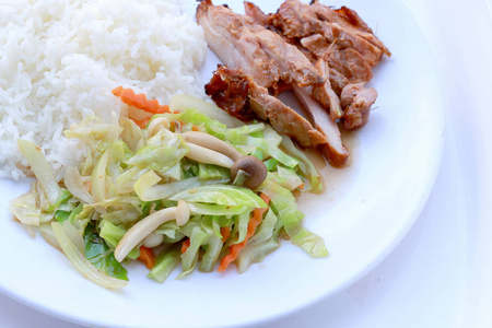 将炒菜和烤鸡胸与泰国茉莉花米在白色盘子中分离在白色背景上。 泰国式食物。