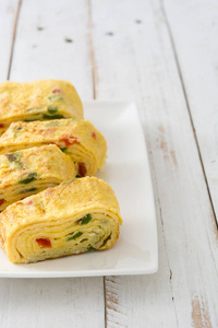 传统的 tamagoyaki 日本煎蛋白色木制的桌子上