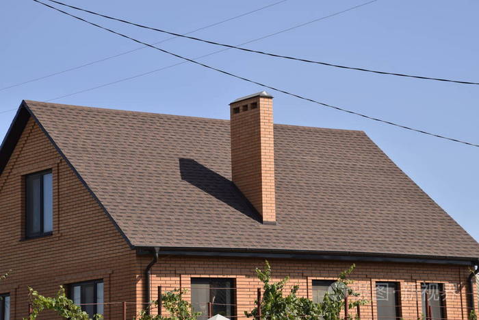 用钢板制成的屋顶的独立房屋. 屋顶金属片. 现代类型的屋顶材料.