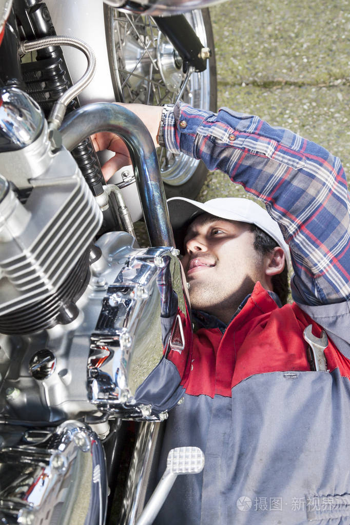 年轻的机修工修理老式摩托车照片-正版商用图片0wjlf0-摄图新视界