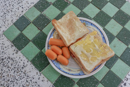 石桌上的烤面包早餐, 包括煎蛋和香肠