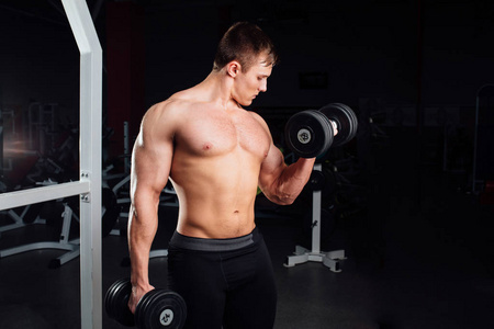 专业的健美运动员肌肉强杨人锻炼的特写肖像。与杠铃在健身房锻炼。体育和健身。培训人打气手二头肌