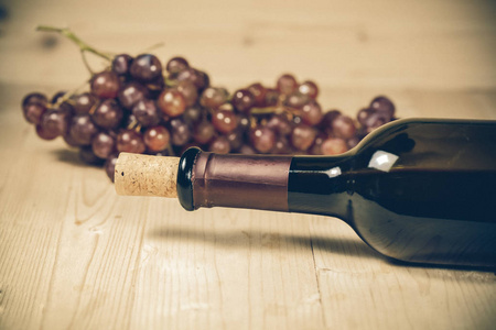 葡萄和葡萄酒瓶上木背景