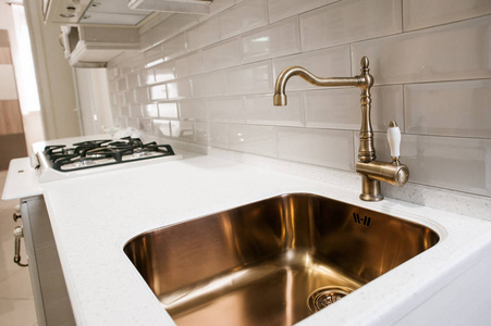 厨房的水槽与黄金水龙头的角度观