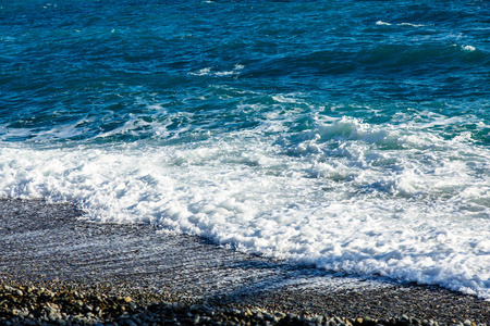 海浪滚落到鹅卵石的海滩上