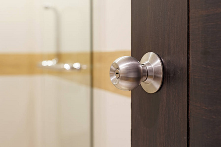 亚洲女性手拿着不锈钢门碰不锈钢门把手白色木门现代不