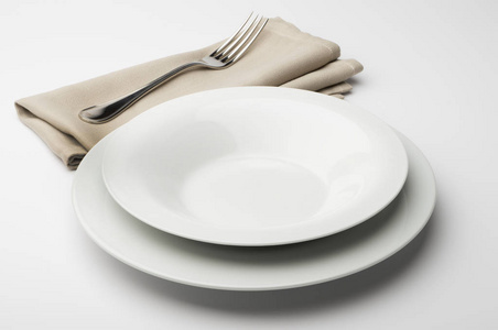 空白色的圆盘和碗拿餐巾刀叉